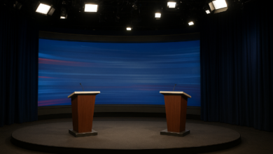 Estúdio de televisão preparado para debate presidencial com púlpitos vazios e iluminação jornalística