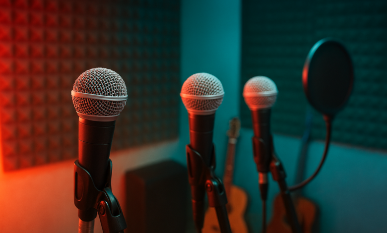 Microfones em estúdio musical com iluminação colorida representando colaboração entre cantores moçambicanos
