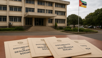Edifício institucional em Moçambique com documentos de segurança social sobre uma mesa