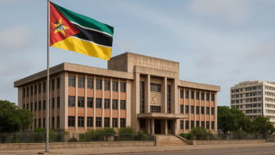 Edifício institucional moçambicano com bandeira nacional em ambiente urbano, imagem fotojornalística realista
