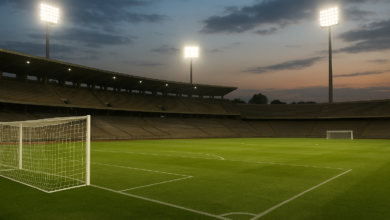 Estádio de futebol iluminado com balizas e relvado, em ambiente editorial realista