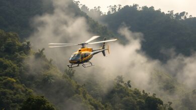 Helicóptero de busca e resgate em missão de patrulha sobre montanhas cobertas por densa vegetação e neblina