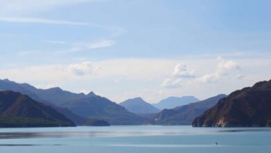 Panorâmica da imensa albufeira de Cahora Bassa com águas calmas e montanhas escarpadas ao fundo