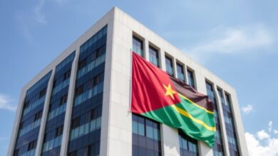Edifício de escritórios modernos sob céu limpo com bandeira de Moçambique num mastro exterior