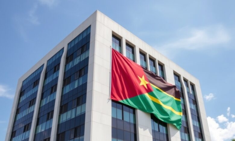 Edifício de escritórios modernos sob céu limpo com bandeira de Moçambique num mastro exterior