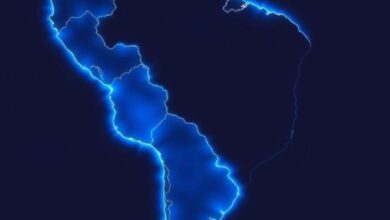 Fotografia de um mapa-múndi iluminado com foco na América Latina e América do Norte em tons azuis.