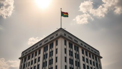 Edifício governamental em Maputo sob céu límpido com bandeira nacional hasteada em mastro solene ao entardecer.